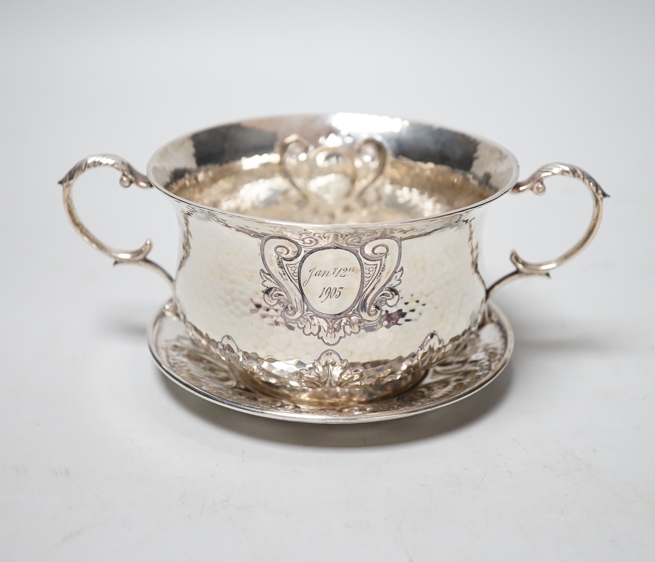 An Edwardian hammered silver two handled porringer on stand, Elkington & Co, London, 1903, diameter 17.7cm over handles, 10.9oz.